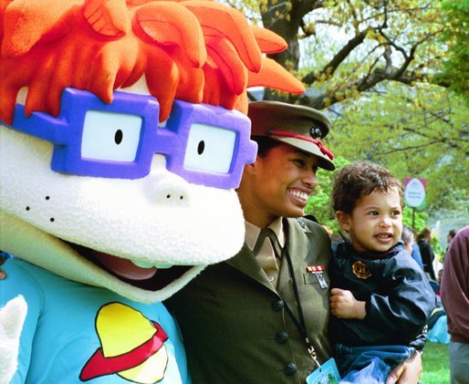 A United States Marine and her son stand for pictures with Chuckie, a character from the cartoon, "Rugrats," during the White House Easter Egg Roll Monday, April 21, 2003. More than 30 children's characters wandered through the South Lawn during the day's festivities, including Clifford the Big Red Dog, Winnie the Pooh and the Berenstain Bears.